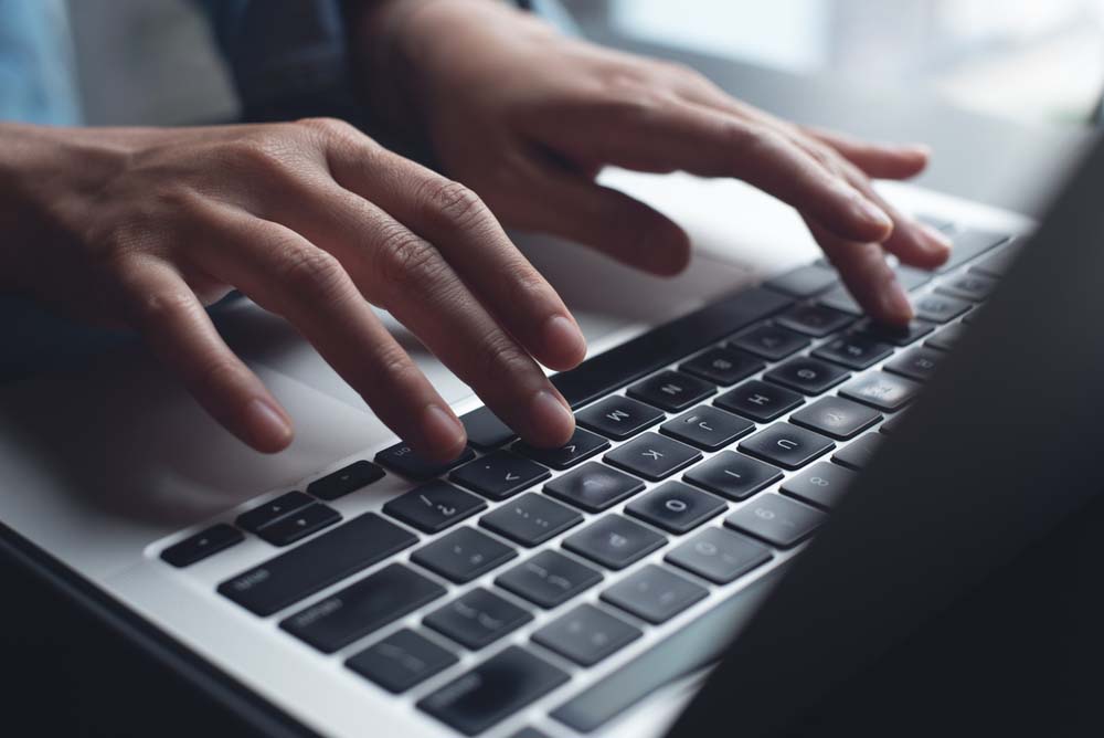 hands typing on a laptop